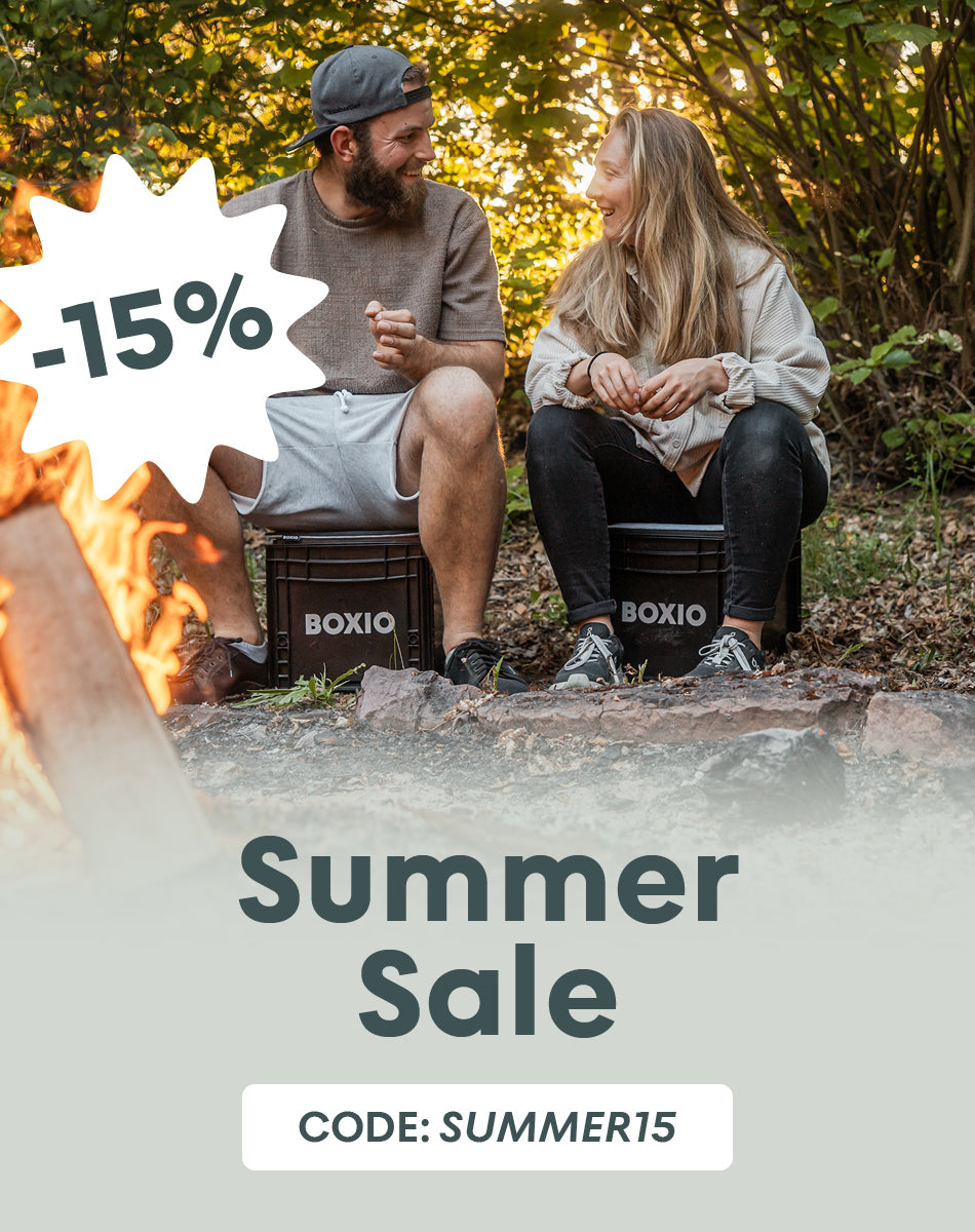 Mann und Frau sitzen auf einer Eurobox auf dem Bild ist ein 15% Störer und ein Hinweis zum Summer sale mit dem Code SUMMER15