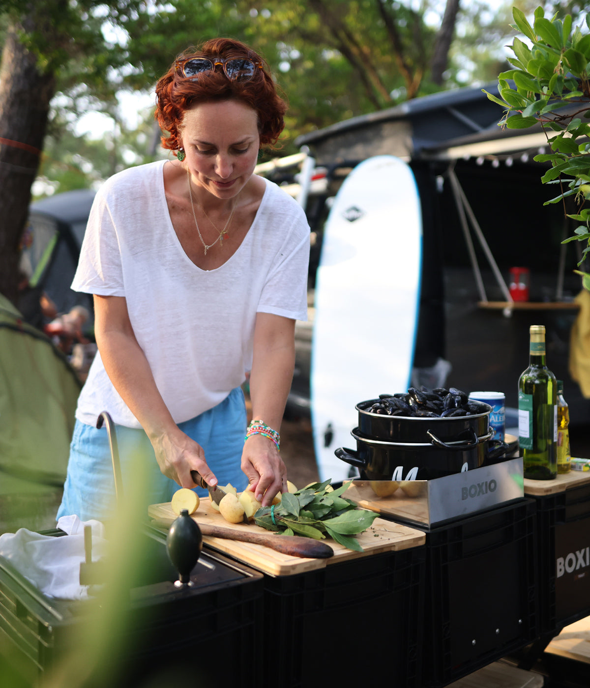 Frau kocht mit Boxio Produkten und ein Surfboard steht im Hintergrund